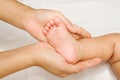 Mother hand massaging foot of her baby