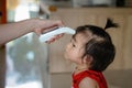 Mother hand measuring temperature baby girl at home . Baby allow mother takeing temperature for toddler with Infrared Royalty Free Stock Photo