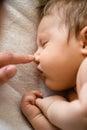 Mother hand touch newborn sleeping baby nose Royalty Free Stock Photo