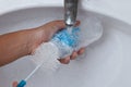 Mother hand washing baby milk bottle on white sink Royalty Free Stock Photo