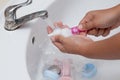 Mother hand washing baby plastic nipple on white sink Royalty Free Stock Photo