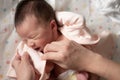 Mother hands changing diaper and clothes to beautiful and adorable newborn baby girl with mixed Asian Caucasian ethnicity in sweet Royalty Free Stock Photo