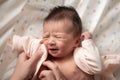 Mother hands changing diaper and clothes to beautiful and adorable newborn baby girl with mixed Asian Caucasian ethnicity in sweet Royalty Free Stock Photo