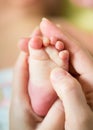 Mother hands holding infant baby foot Royalty Free Stock Photo