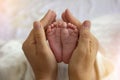 Mother Hands Holding Small Baby Feet. Close-up Tiny Baby Feet in Hands. Royalty Free Stock Photo