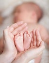 Mother hands holding small baby's feet