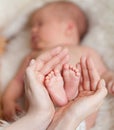 Mother hands holding small baby's feet