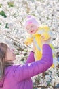 Mother hands throws up child in the blooming apple trees Royalty Free Stock Photo