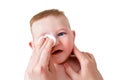 Mother hands wash the eyes of a happy infant baby with a cotton pad, Royalty Free Stock Photo