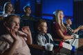 Mother with happy small children in the cinema, watching film.