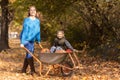 Mother have fun time with kids, use garden wheelbarrow