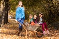 Mother have fun time with kids, use garden wheelbarrow