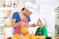 Mother with healthy orange juice and her happy little child