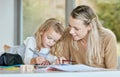 Mother help youth girl with school work, homework or preschool education while writing in notebook. Mom helping Royalty Free Stock Photo