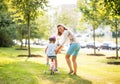 Mother helping baby girl riding on bicycle Royalty Free Stock Photo