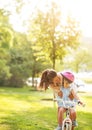 Mother helping baby girl riding bicycle outdoors Royalty Free Stock Photo