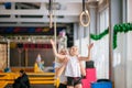 Mother helping daughter to play sports on gymnastic rings Royalty Free Stock Photo