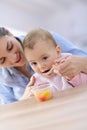 Mother helping her baby eating Royalty Free Stock Photo