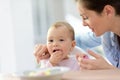 Mother helping her baby girl eating Royalty Free Stock Photo