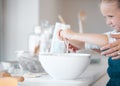 Mother helping her daughter crack an egg into a bowl. Little girl cracking an egg into a bowl. Caucasian child baking Royalty Free Stock Photo