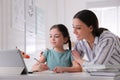 Mother helping her daughter doing homework with tablet at home Royalty Free Stock Photo