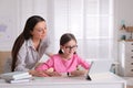 Mother helping her daughter doing homework with tablet at home Royalty Free Stock Photo