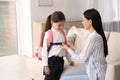 Mother helping her little daughter to get ready for school indoors Royalty Free Stock Photo