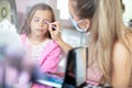 Mother helping her little girl with make up Royalty Free Stock Photo