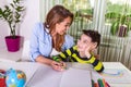 Mother helping with homework to her son indoor. Family, children and happy people concept. Mother and sons drawing together, mom Royalty Free Stock Photo