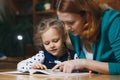 Mother helping kid after school. preschooler doing homework with help of tutor. home teaching concept. Royalty Free Stock Photo