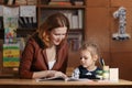 Mother helping kid after school. preschooler doing homework with help of tutor. home teaching concept. Royalty Free Stock Photo