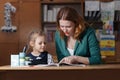 Mother helping kid after school. preschooler doing homework with help of tutor. home teaching concept. Royalty Free Stock Photo