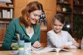 Mother helping kid after school. preschooler doing homework with help of tutor. home teaching concept. Royalty Free Stock Photo