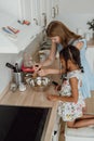 Mother is helping the little girl to add spice to the mixed egg. Royalty Free Stock Photo