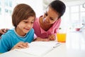 Mother Helping Son With Homework In Kitchen Royalty Free Stock Photo