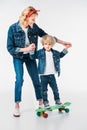 mother helping son standing on skateboard Royalty Free Stock Photo