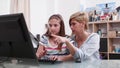 Mother helping young child with school homework explaining mathematics lesson