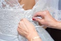 Mother helps the bride to put on a wedding dress. Hands tie a corset of a wedding dress, a close up Royalty Free Stock Photo