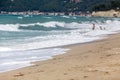 A mother helps her children enjoy the beach.