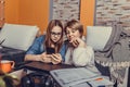 Mother helps her daughter with homework, while they are together browsing internet on smartphone Royalty Free Stock Photo