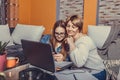 Mother helps her teenage daughter with homework, while they are together browsing internet on smartphone Royalty Free Stock Photo
