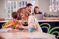 Mother Helps Son With Electronics Project Sitting At Kitchen Table At Home With Laptop Royalty Free Stock Photo