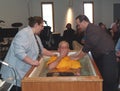 A mother helps to baptize her son
