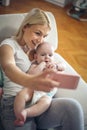 Mother with her baby boy at home taking self portrait wit Royalty Free Stock Photo