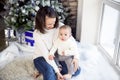 Mother with her baby boy siting near the Christmas tree Royalty Free Stock Photo