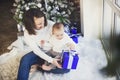 Mother with her baby boy siting near the Christmas tree Royalty Free Stock Photo