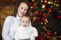 Mother with her baby boy siting near the Christmas tree Royalty Free Stock Photo