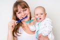 Mother and her baby brushing teeth together