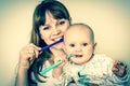 Mother and her baby brushing teeth together - retro style Royalty Free Stock Photo