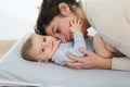 Mother and her baby cudling on a changing table